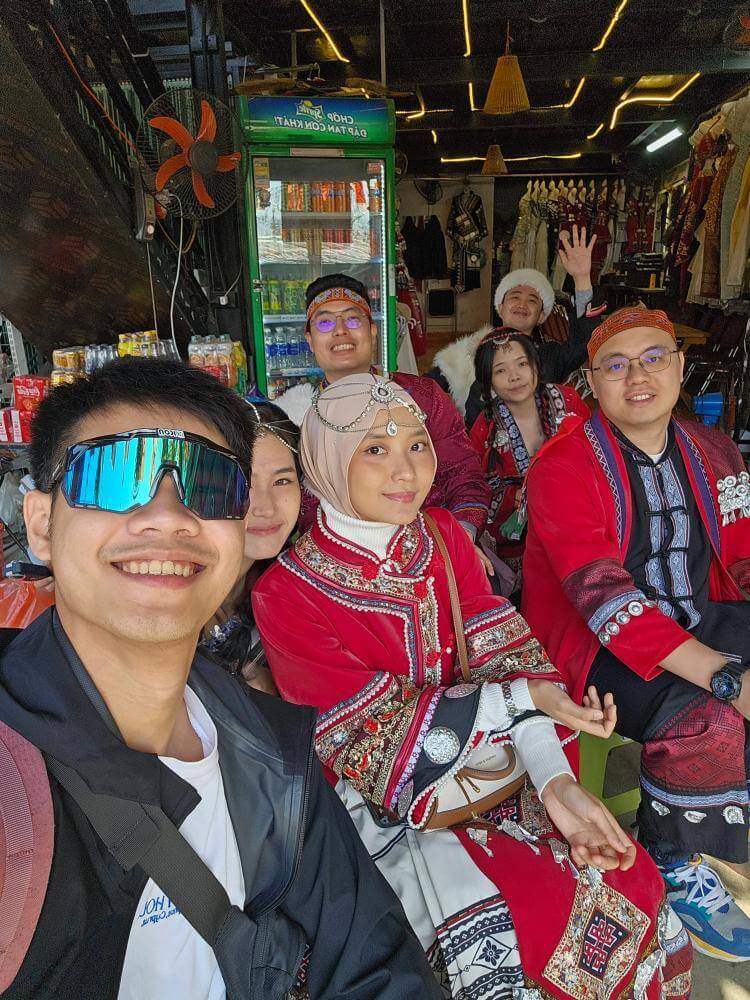 MedicalMet team members exploring a local market in Sapa, Vietnam and trying on traditional clothing